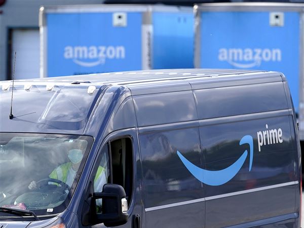 An Amazon Prime logo appears on the side of a delivery van as it departs an Amazon Warehouse location in Dedham, Mass., Oct. 1, 2020.