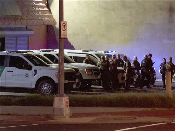 Agents with U.S. Customs and Border Protection, as well as Metropolitan Police, wait in a parking lot Wednesday before driving along Kennedy Street NW in a caravan in northwest Washington.