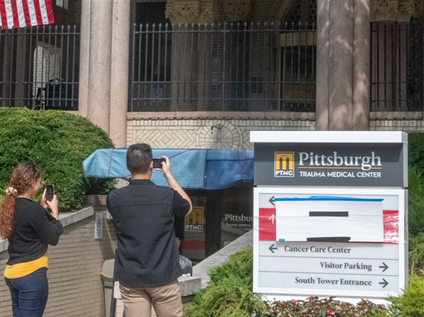 People take photos of the signage outside of Allegheny General Hospital referencing the fictional Pittsburgh Trauma Medical Center, where much of "The Pitt" takes place.